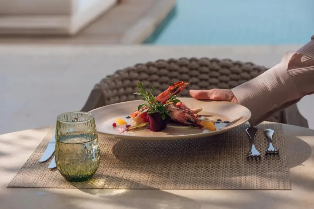 Une assiette de fruits de mer est servie à table en extérieur.