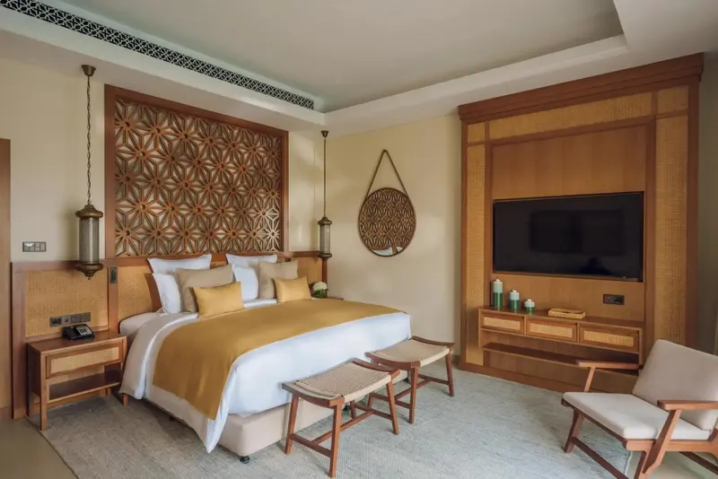 Une chambre lumineuse avec un grand lit et une décoration murale en bois.