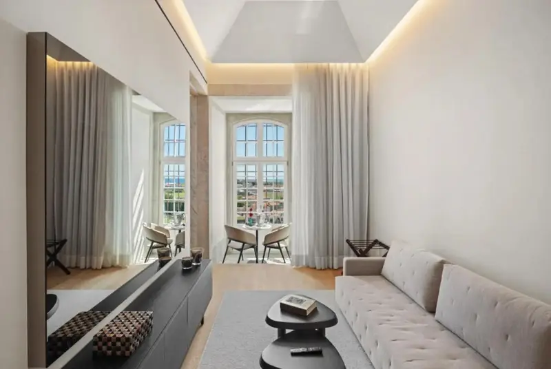 Espace de vie lumineux avec canapé et table à manger près d'une fenêtre.