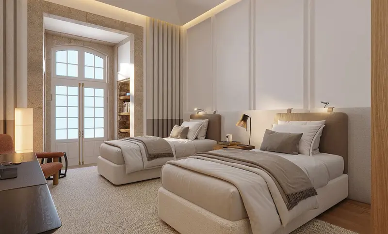 Une chambre lumineuse avec deux lits simples et une fenêtre cintrée.
