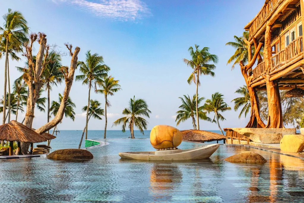 Une piscine à débordement offre une vue sur la mer et la végétation tropicale.