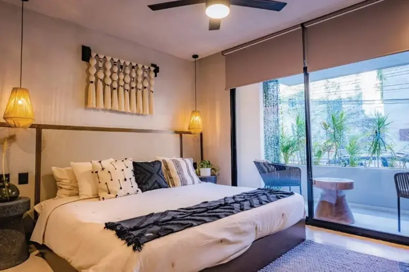 Une chambre lumineuse avec un grand lit et un accès à une terrasse.