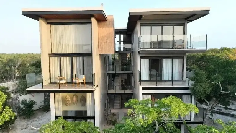 Architecture moderne avec des balcons et de grandes fenêtres donnant sur la végétation.