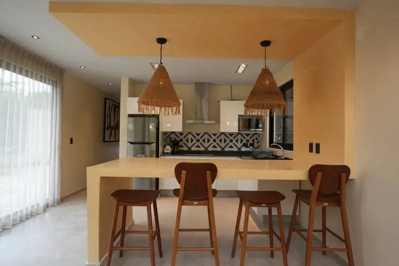 Un espace de repas moderne avec un comptoir et des tabourets hauts.