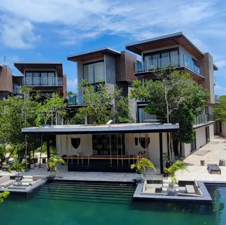 Architecture moderne avec des bâtiments cubiques et une piscine turquoise.