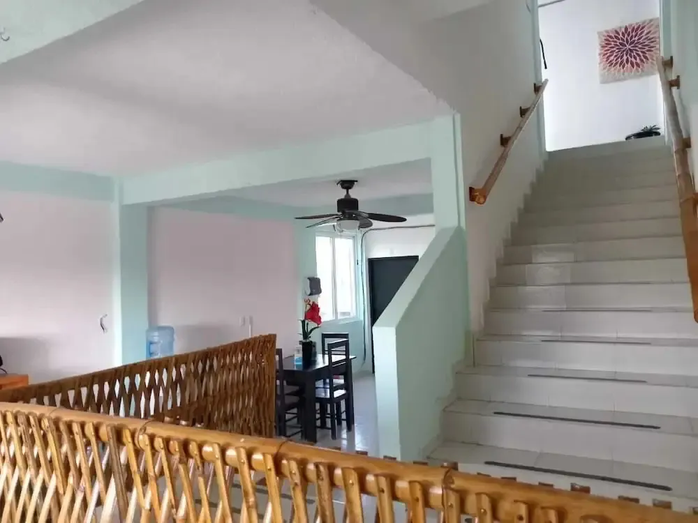 Un escalier en pierre mène à l'étage supérieur d'un intérieur clair.