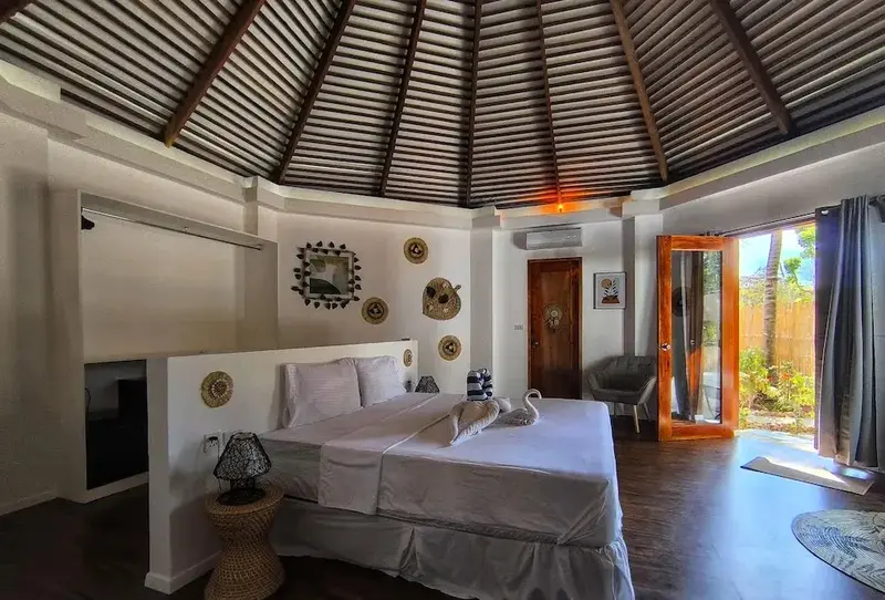 Une chambre lumineuse avec un lit king-size et un accès à une terrasse.