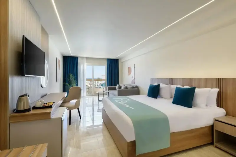 Une chambre lumineuse avec un grand lit et un coin salon.