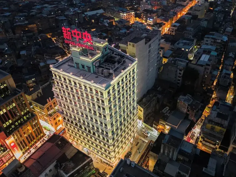Vue aérienne d'un bâtiment illuminé au cœur d'une ville nocturne.