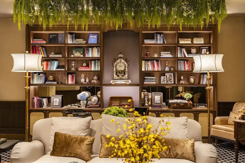 Un espace de détente intérieur avec des canapés, des bibliothèques et des lampes.