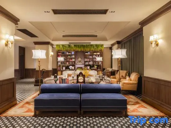 Un salon chaleureux avec des canapés, des fauteuils et une bibliothèque décorative.