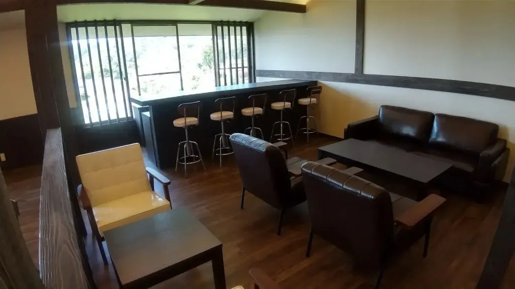 Un espace de détente avec un bar et des fauteuils confortables.