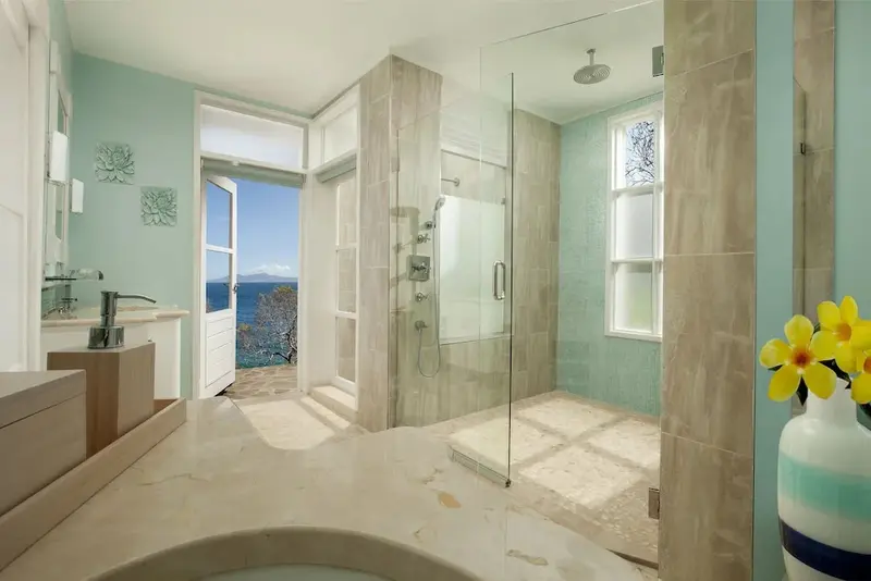 Une salle de bain lumineuse avec une douche à l'italienne et une vue sur la mer.