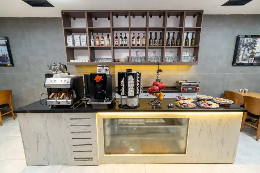 Un comptoir de boissons propose des cafés et des fruits frais.