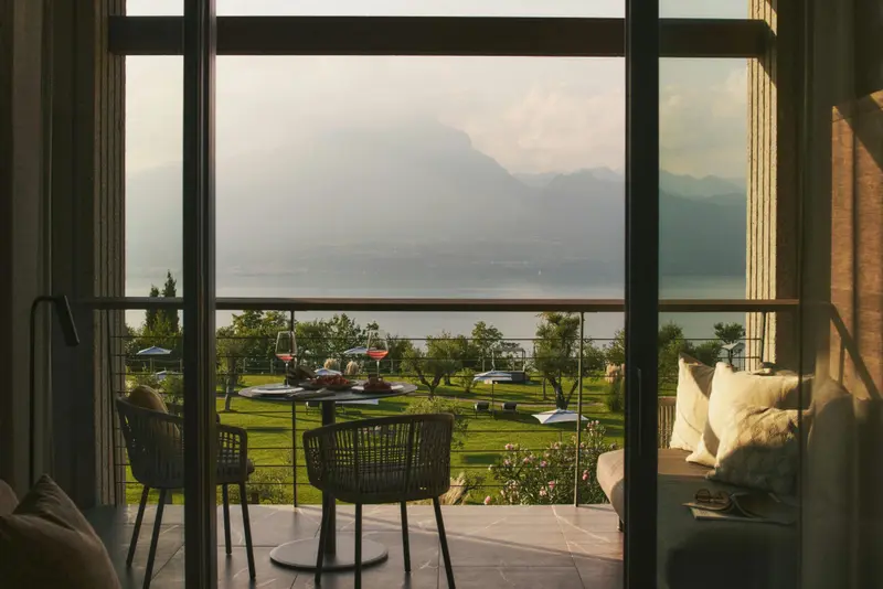 Vue sur un paysage montagneux depuis une terrasse aménagée avec des chaises et une table.