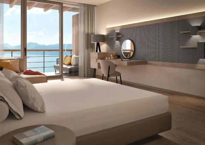 Une chambre lumineuse avec un grand lit donnant sur une vue mer.