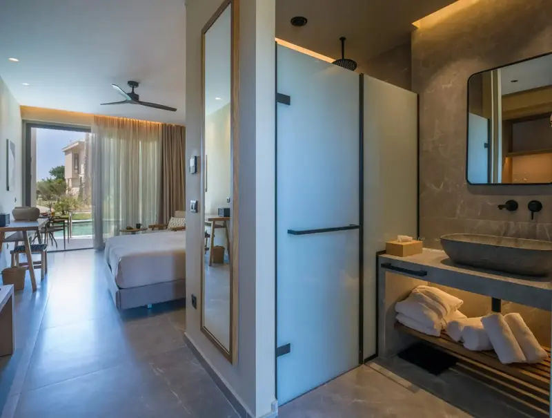 Une chambre moderne avec salle de bain attenante et vue sur l'extérieur.