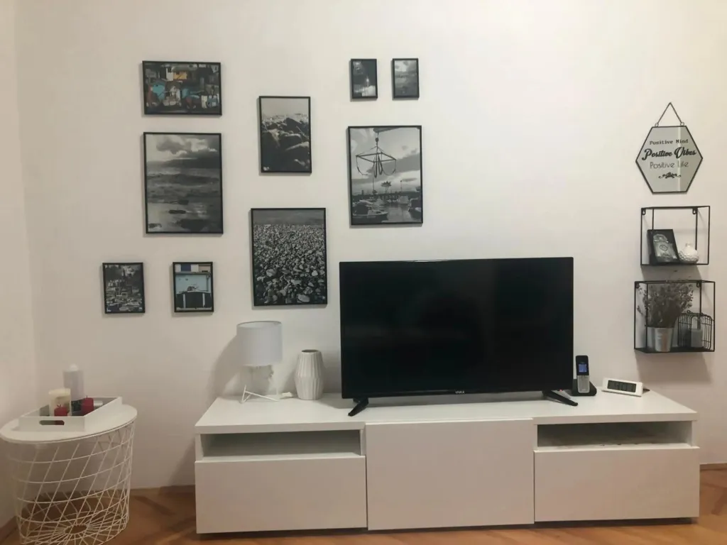 Un salon moderne avec un téléviseur et des cadres au mur.