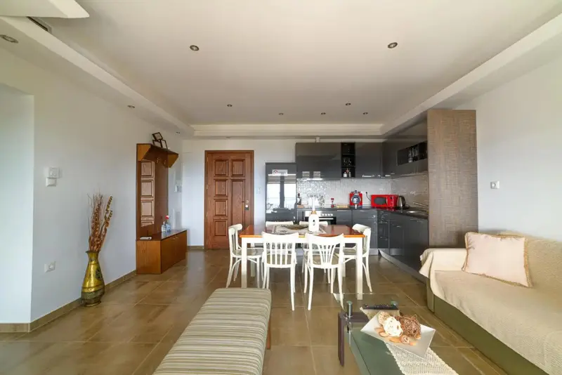 Espace de vie lumineux avec cuisine équipée et coin repas.