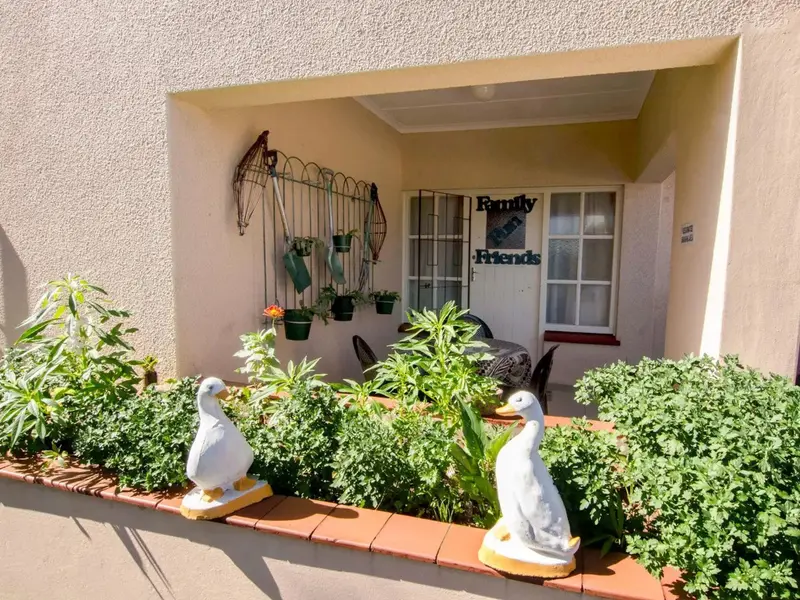 Une entrée de logement décorée de plantes et de statues d'oiseaux.