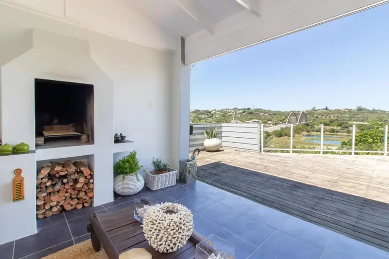 Terrasse avec barbecue intégré et vue sur un paysage verdoyant.