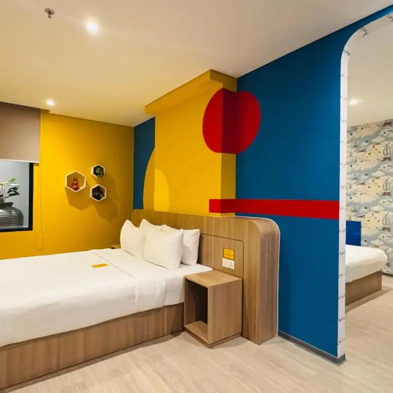 Chambre colorée avec un grand lit et un espace repos.