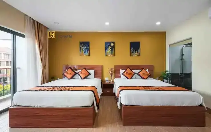 Une chambre lumineuse avec deux lits simples et une décoration murale colorée.