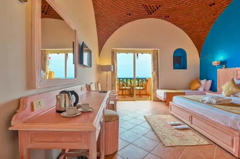 Une chambre lumineuse s'ouvre sur une terrasse avec vue sur la mer.