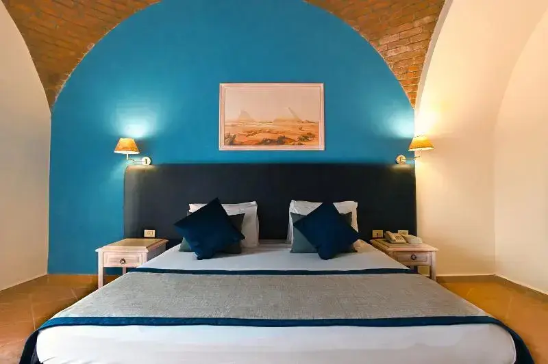 Une chambre à coucher lumineuse avec un grand lit et un décor mural en arc.