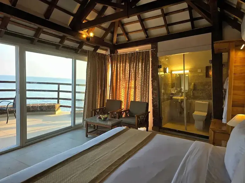 Une chambre lumineuse avec un lit et un espace salon donnant sur la mer.