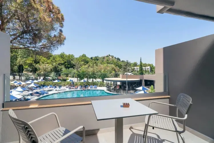 Une terrasse aménagée offre une vue sur une piscine et des transats.