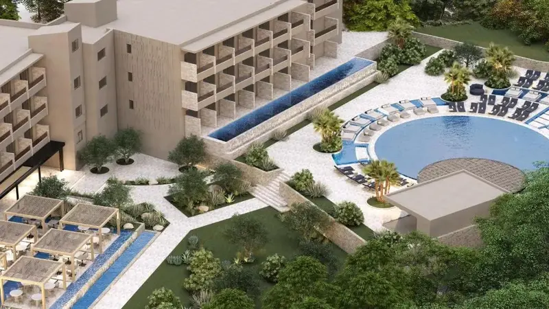 Vue aérienne d'un complexe hôtelier avec piscine et végétation luxuriante.
