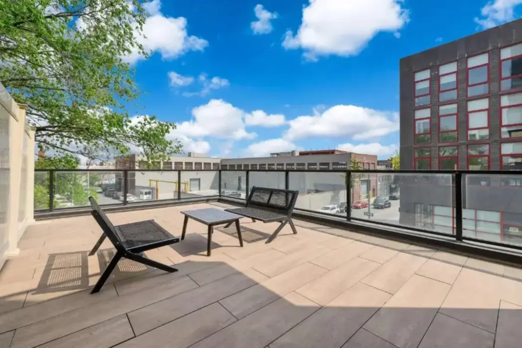Terrasse aménagée avec mobilier de jardin et vue sur la ville.