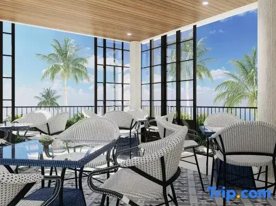 Une salle à manger lumineuse avec de grandes baies vitrées donnant sur une végétation tropicale.