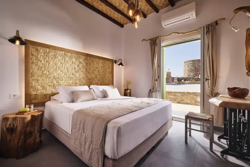 Une chambre lumineuse avec un grand lit et un accès à une terrasse.