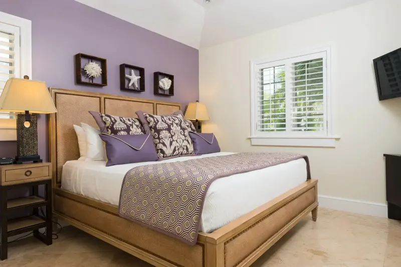 Une chambre lumineuse avec un grand lit recouvert d'une courtepointe décorative.