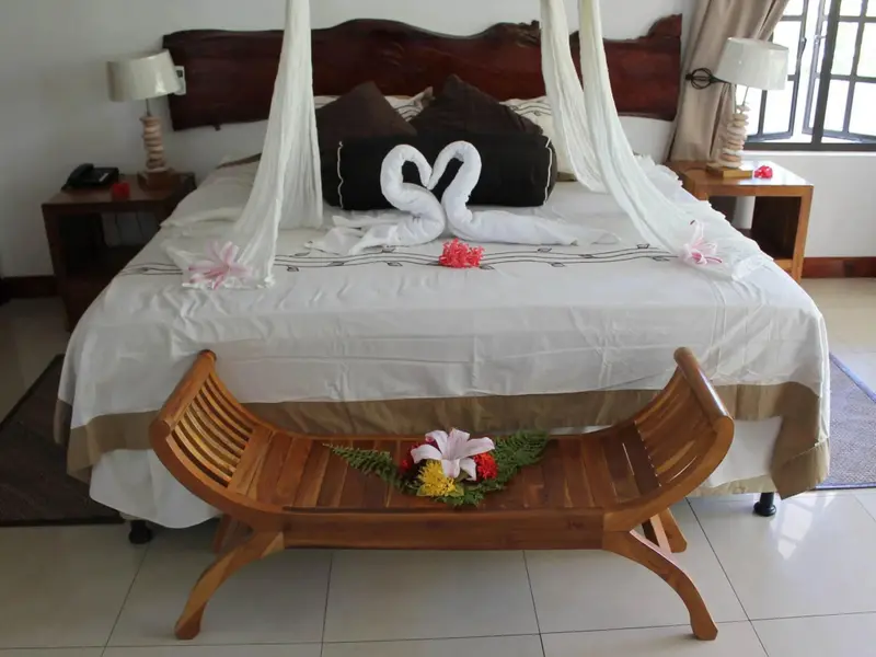 Une chambre avec un lit à baldaquin décoré de fleurs et de serviettes en forme de cœur.