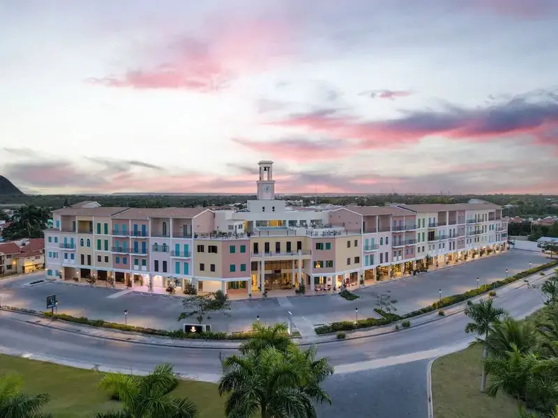 Vue aérienne d'un bâtiment aux façades colorées sous un ciel crépusculaire.
