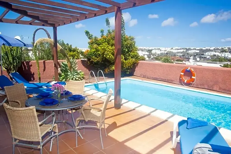 Terrasse avec piscine et mobilier de jardin.
