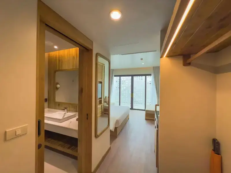 Une chambre lumineuse s'ouvre sur une salle de bain moderne.
