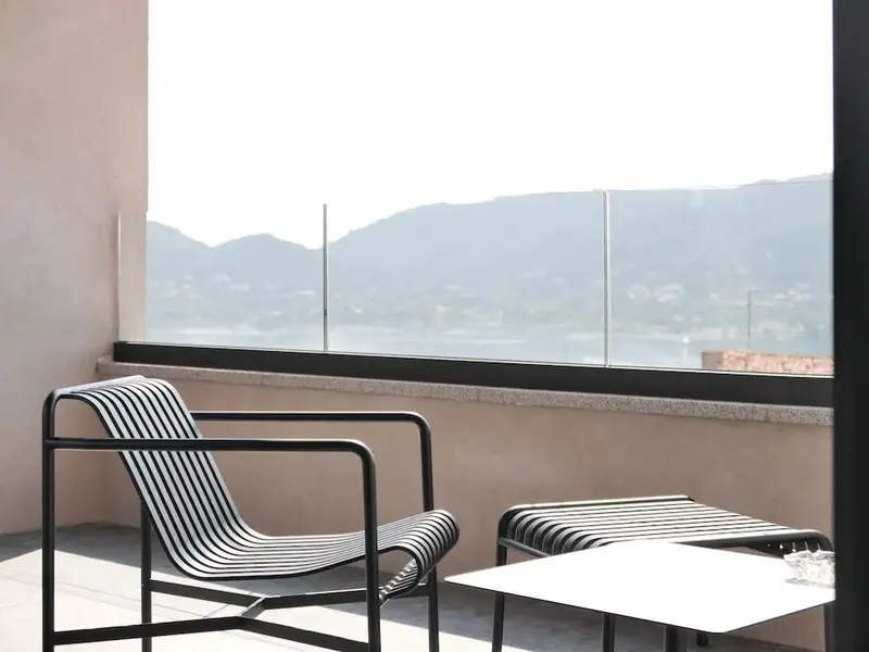 Terrasse avec mobilier d'extérieur et vue sur un paysage montagneux.
