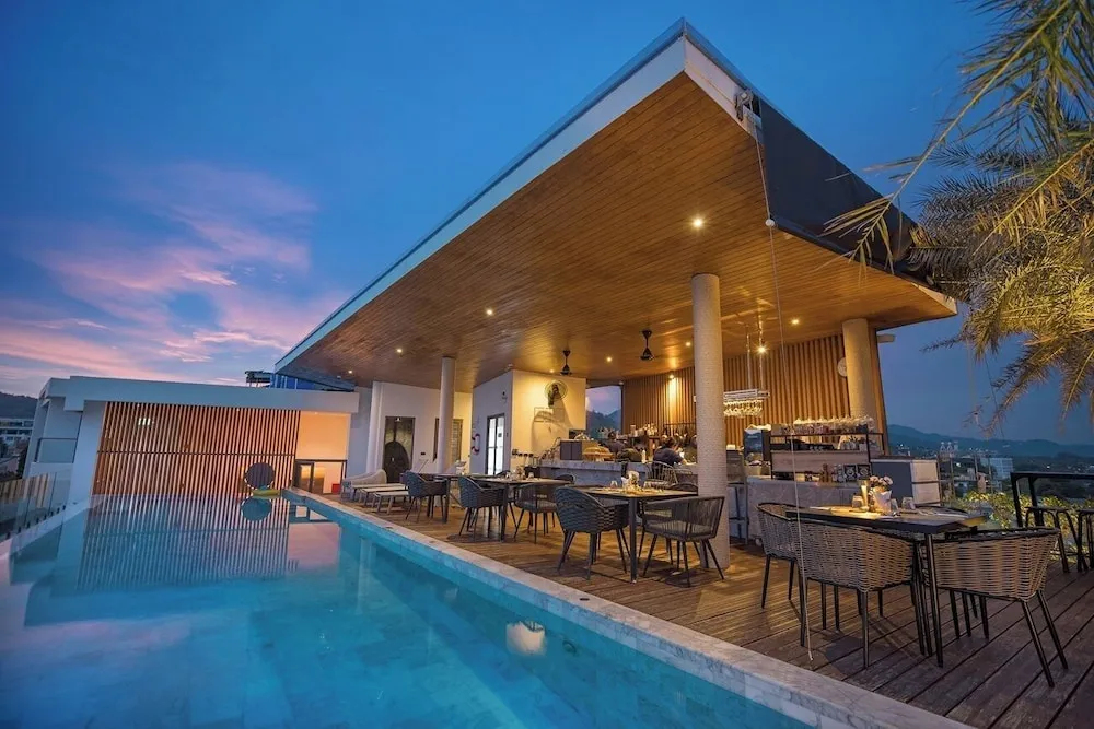 Terrasse avec piscine et espace bar au crépuscule.