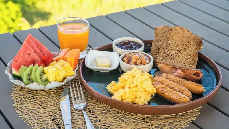 Un petit-déjeuner copieux est présenté sur une table extérieure.