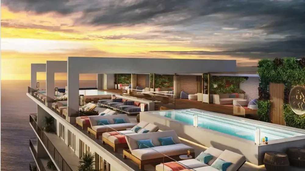 Terrasse avec piscine et mobilier de détente au coucher du soleil.