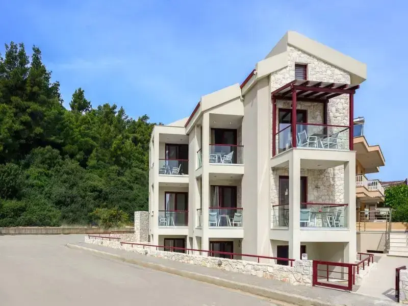Bâtiment moderne à plusieurs étages avec des balcons et une façade en pierre.