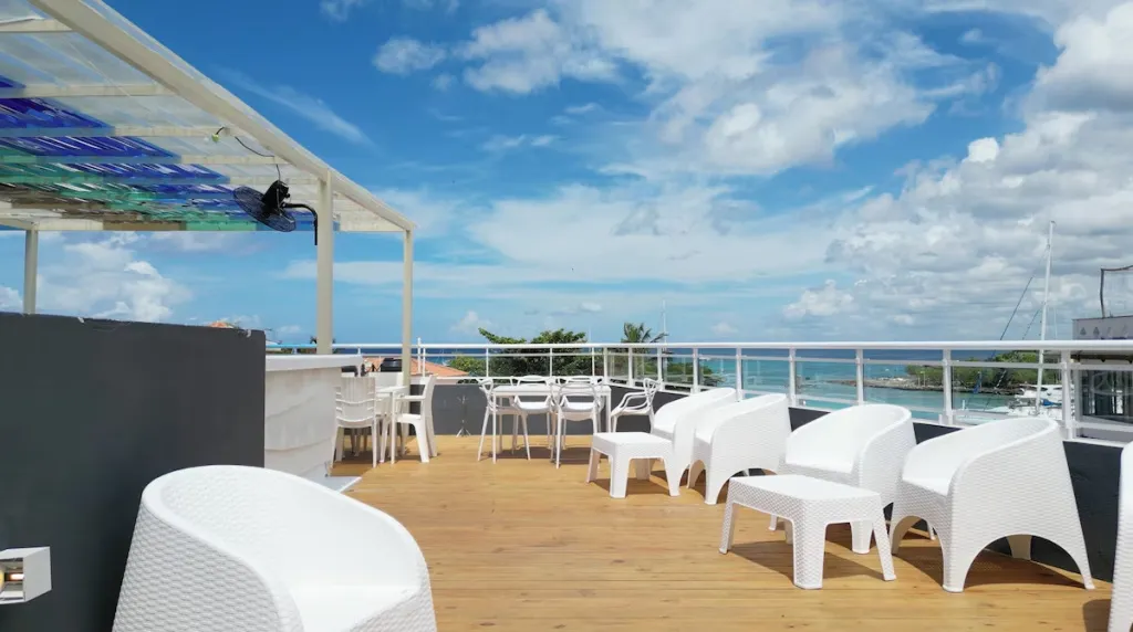 Terrasse aménagée avec mobilier blanc et vue sur la mer.