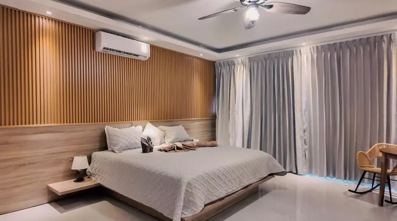 Une chambre lumineuse avec un grand lit et un mur en lambris.