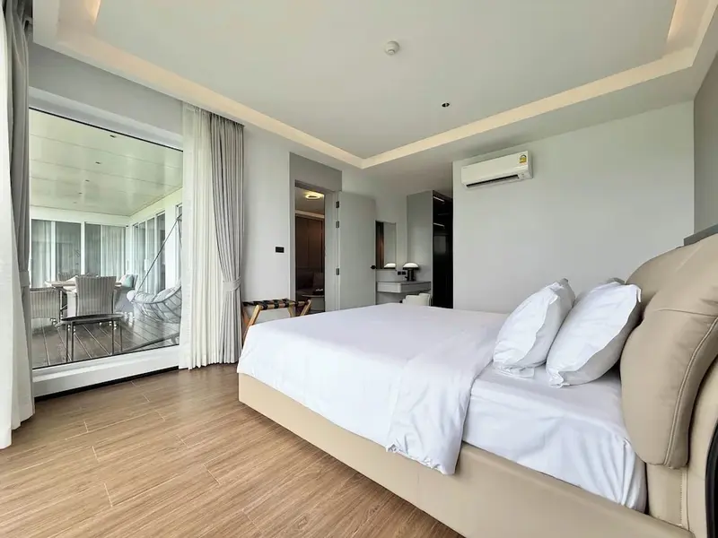 Une chambre lumineuse avec un grand lit et un accès à une terrasse.