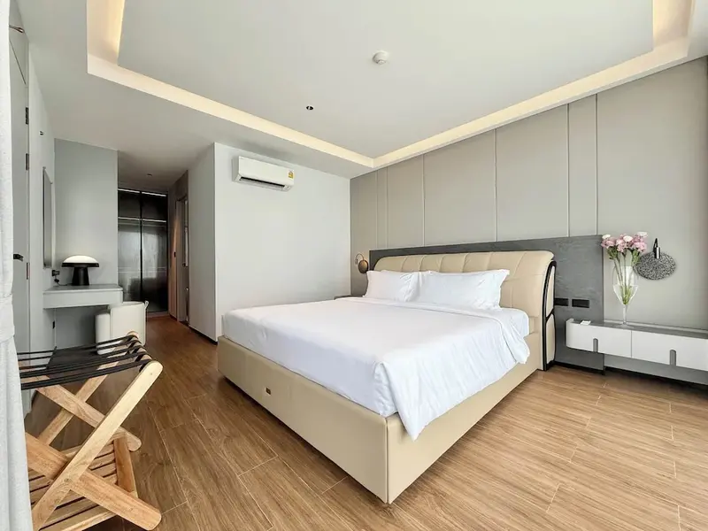 Une chambre lumineuse avec un grand lit et un coin repos.