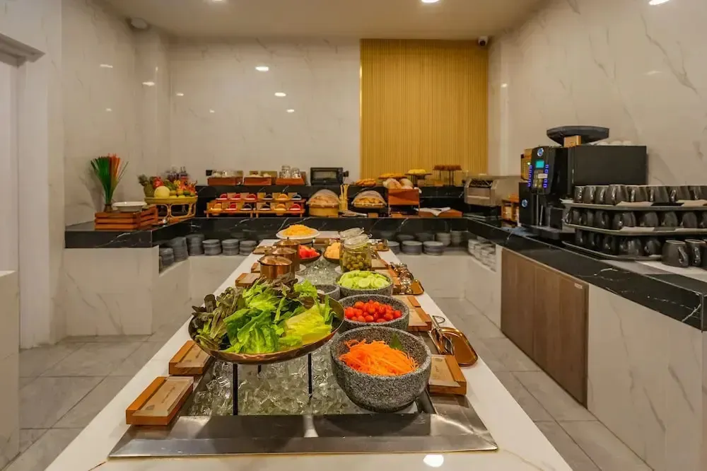 Un buffet propose une variété de plats et de boissons dans une salle lumineuse.